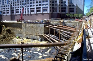 Diagonal braces are used to support the side of the excavation that borders Market Street, and the below-ground BART transit tubes. The excavation wall along the street side consists of reinforced concrete diaphragm wall constructed in-situ in overlapping panels before the excavation started.