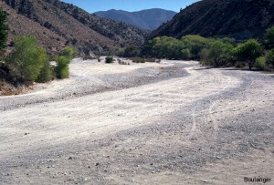 This is a view of the valley floor upstream of Littlerock dam. The ground surface is comprised of sand and gravelly sand. A series of test pits were excavated in this area to determine the quantity and quality of aggregate materials that might be used in a roller compacted concrete modification of the existing dam.