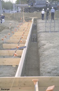 This trench extends along the outer wall of the building.  Notice the vertical rebar dowels extending out of completed CIDH (cast in drilled hole) piles at each of the main column locations.