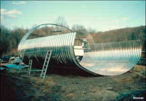 Large culvert structures like this one are shipped to the job site in pieces and bolted together at the site. They can be erected with light equipment and unskilled labor, but experienced supervision is essential.