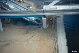 A segment of this new bridge (Nishinomiya bridge) collapsed because of foundation deformations that are attributed to the effects of liquefaction. Ground cracks behind the quay walls and parallel to the water edge are indicative of the lateral ground movements that occurred. Sand boils are visible on the ground surface.