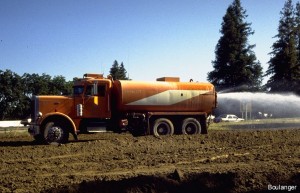 The water truck sprays the earth during compaction to condition the soil to near its optimum moisture content for compaction, and to control dust at the site.